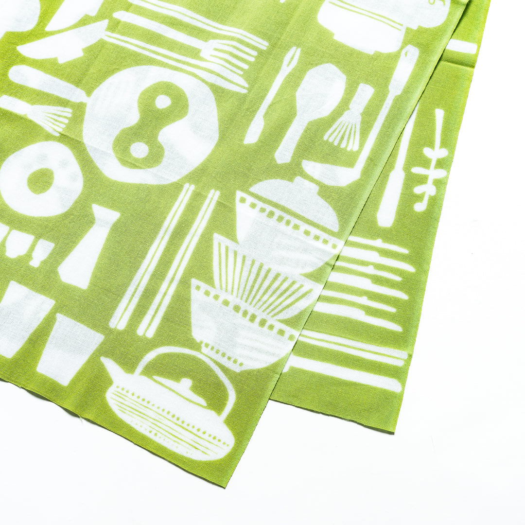 Close-up of the green tenugui hand towel, showing detailed white kitchenware patterns, including bowls, chopsticks, and teapots.