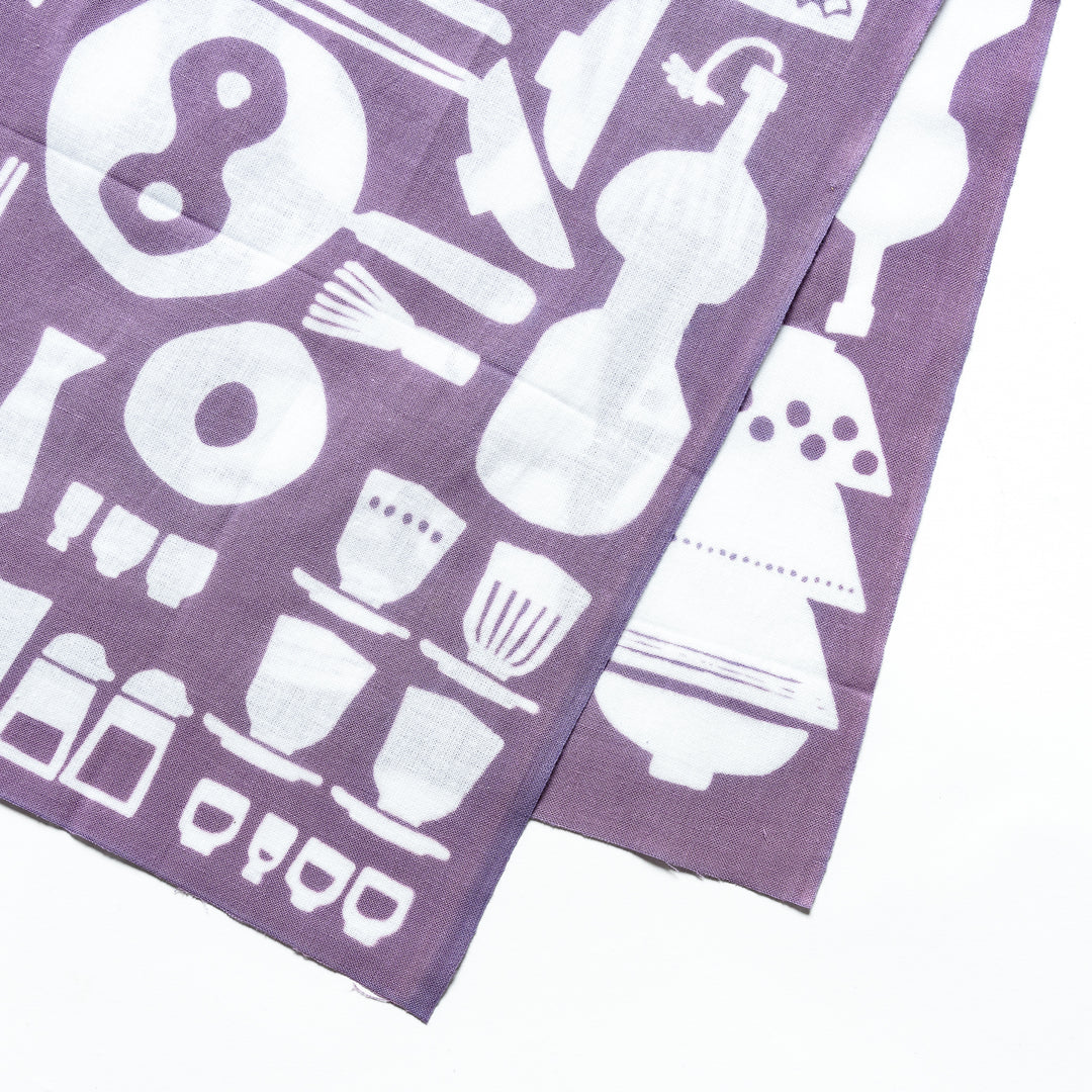 Close-up of the purple tenugui hand towel, showcasing white kitchenware patterns such as bowls, utensils, and teapots with fine detail.