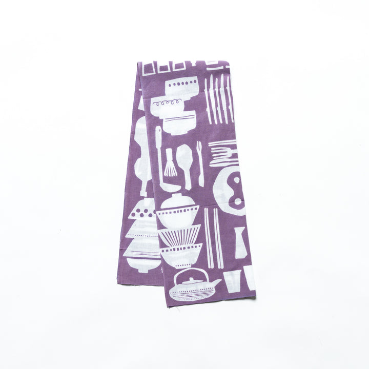 Purple tenugui hand towel with white kitchenware patterns, folded to highlight its rich color and elegant design.