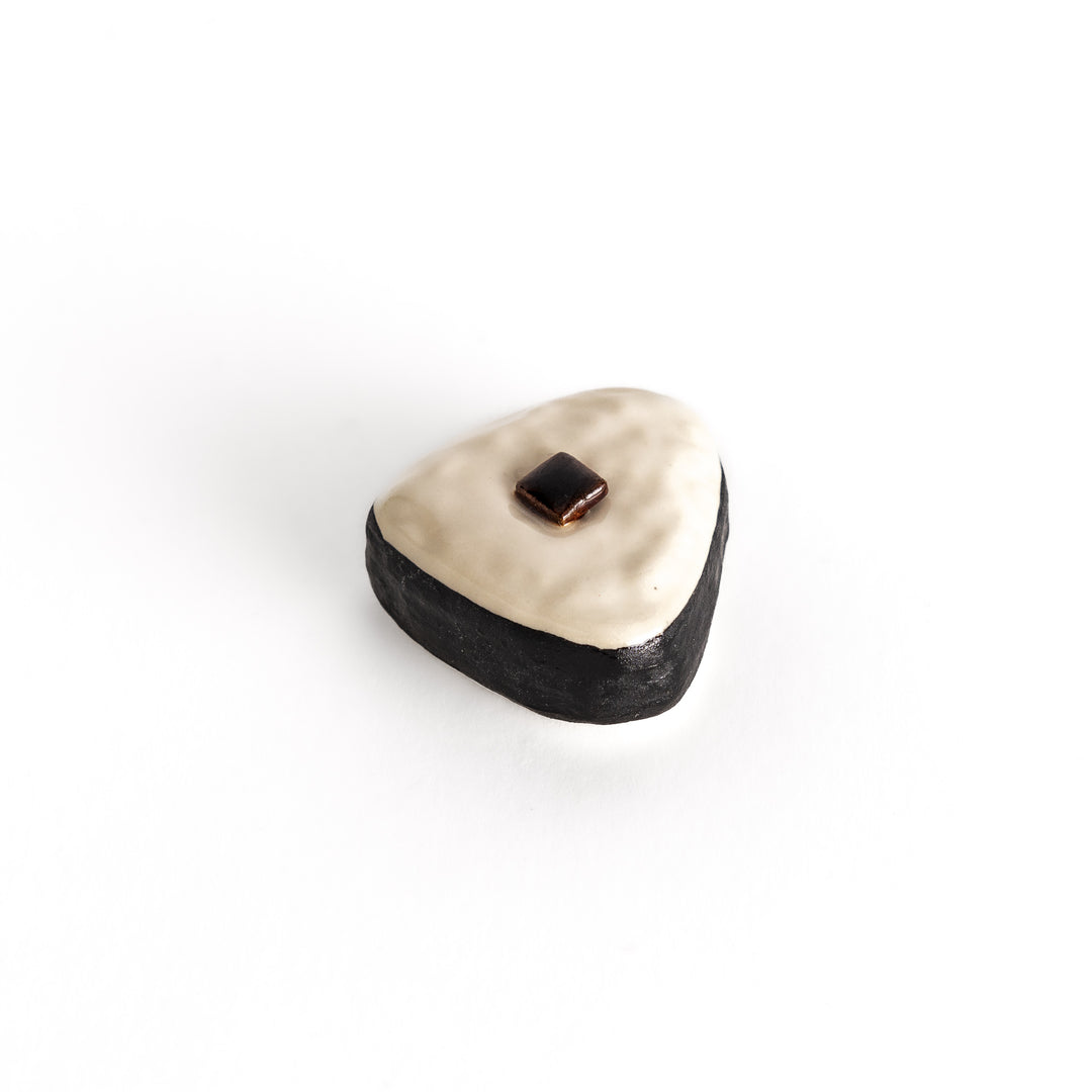 Angled view of the onigiri-shaped chopstick rest, emphasizing its three-dimensional texture and kombu seaweed centerpiece.