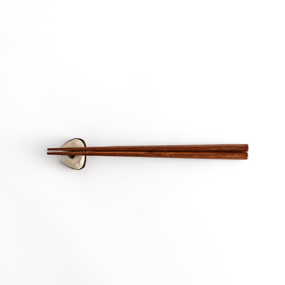 Distant view of chopsticks placed on the onigiri-shaped chopstick rest, showcasing its overall design and unique shape.