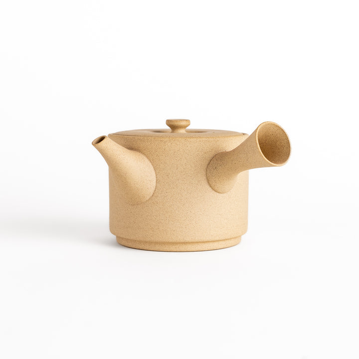 Modern beige teapot with a round body, horizontal spout, and lid, crafted from textured ceramic for a minimalist tea experience.