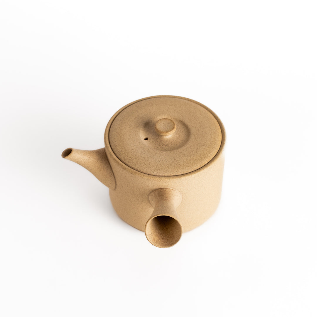 Beige teapot with the lid removed, revealing a smooth interior, presented in a clean top-down perspective.