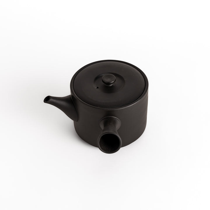 Slightly angled view of the black teapot, highlighting its balanced shape and horizontal spout and handle.