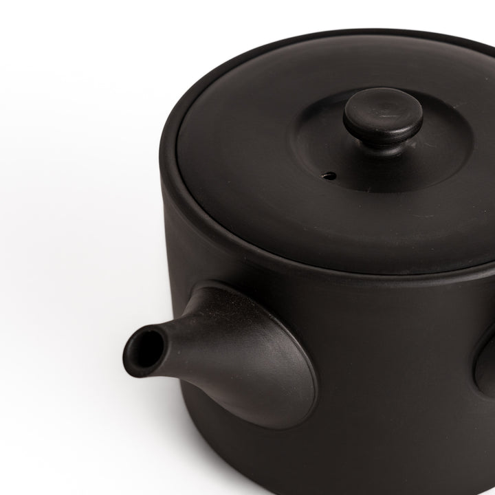 Close-up of the black teapot’s spout, showcasing its refined craftsmanship and textured surface.