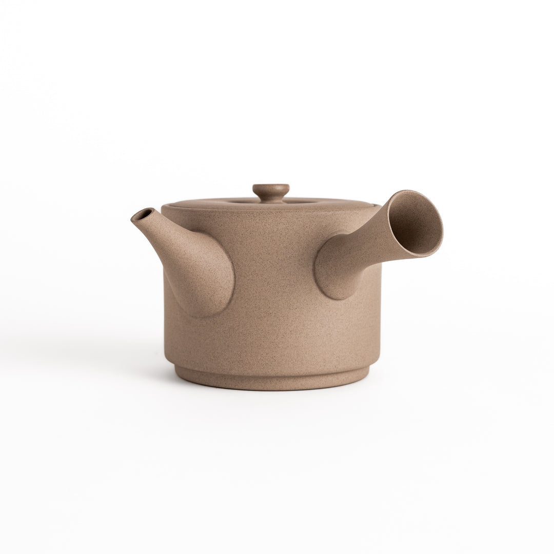 Modern gray teapot with a round body, horizontal spout, and lid, crafted from textured ceramic for a minimalist tea experience.