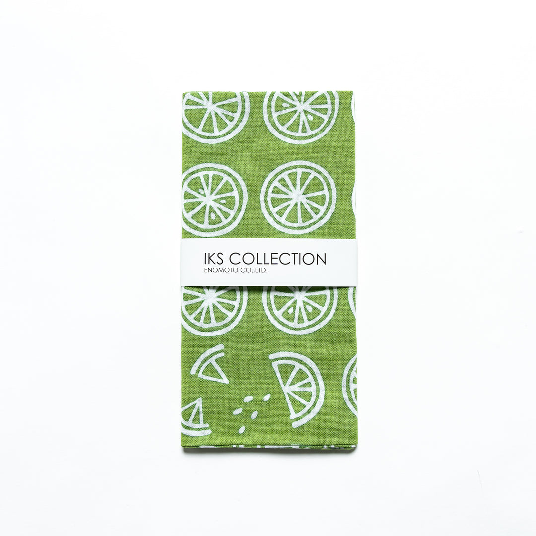 Folded green tenugui showcasing lime slice patterns, wrapped with a product sleeve.