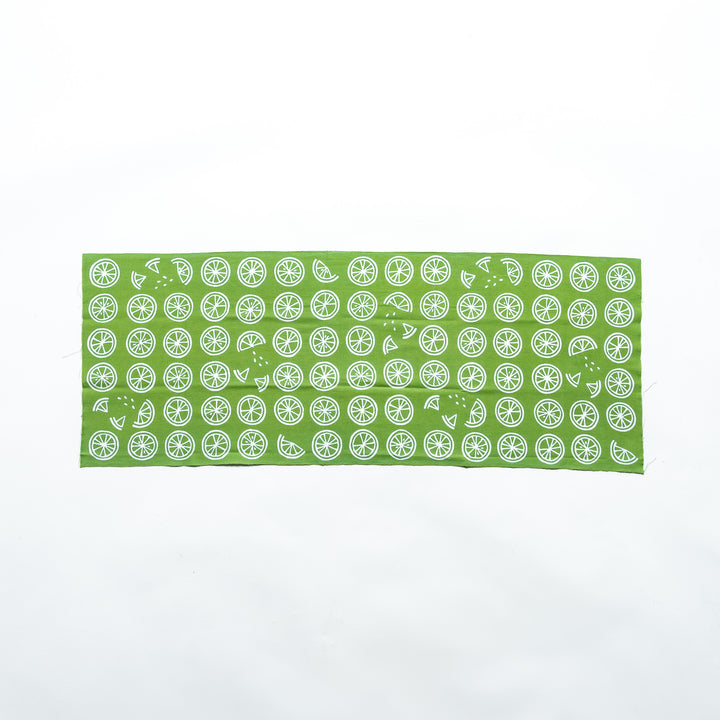 Green tenugui fully unfolded, highlighting the lime slice and wedge motifs.