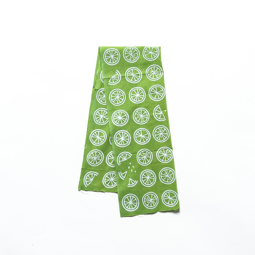 Green tenugui decorated with white lime slices and wedges in a repeating design.