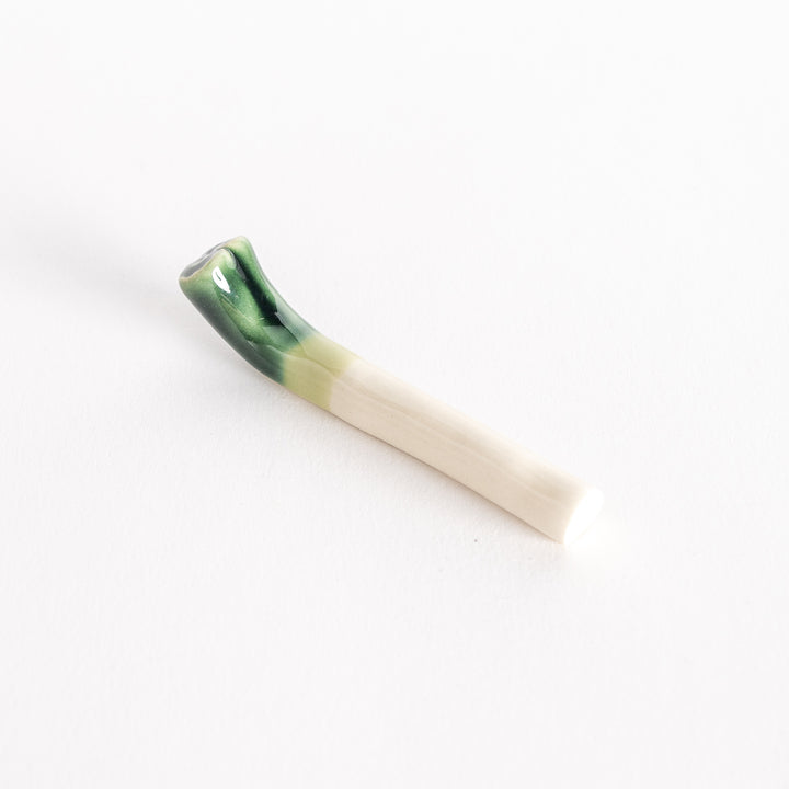 Slightly angled view of the glossy green onion chopsticks rest, showcasing its smooth ceramic finish.