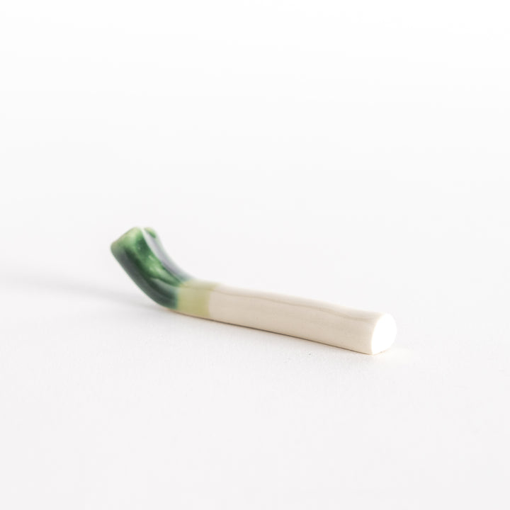 Side view of the ceramic green onion chopsticks rest, highlighting its elongated shape and curved edges.