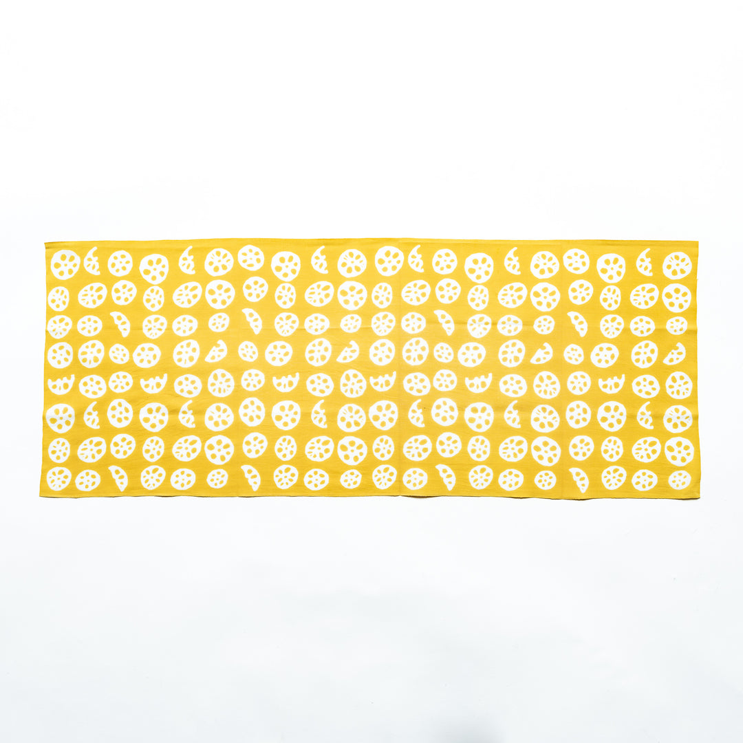 Yellow hand towel showcasing white lotus root slice patterns, fully spread.