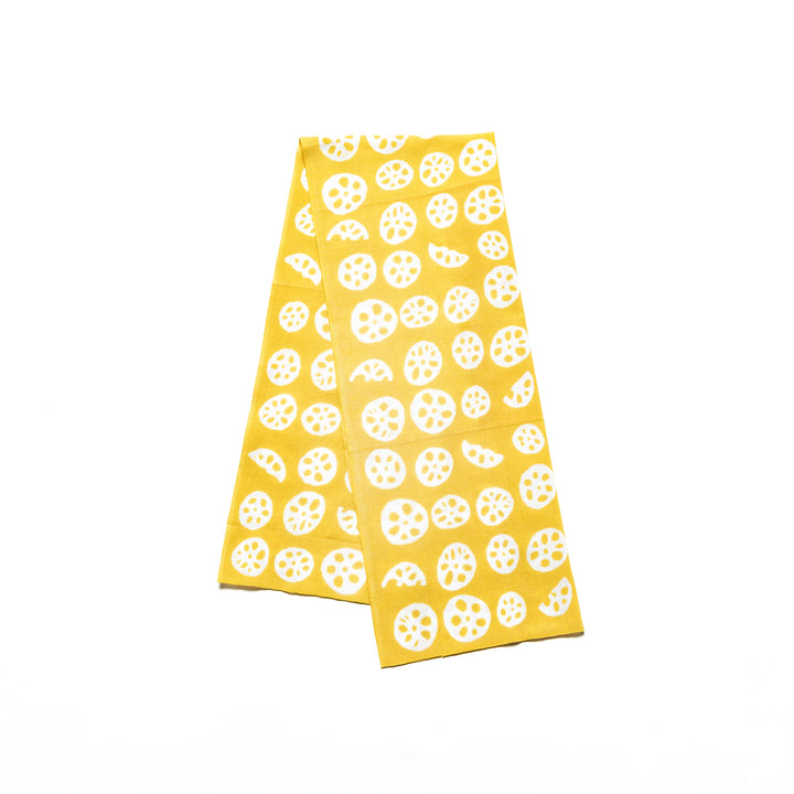 Yellow hand towel with white lotus root slice patterns neatly folded.