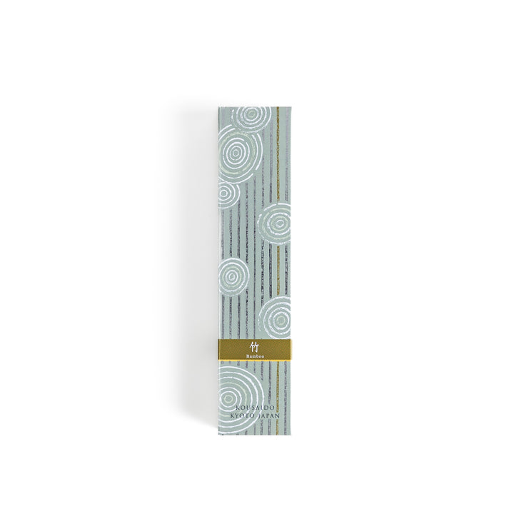 Incense in a light wooden box with earthy green sticks, featuring an elegant soft green package adorned with white circular patterns for a serene aesthetic.