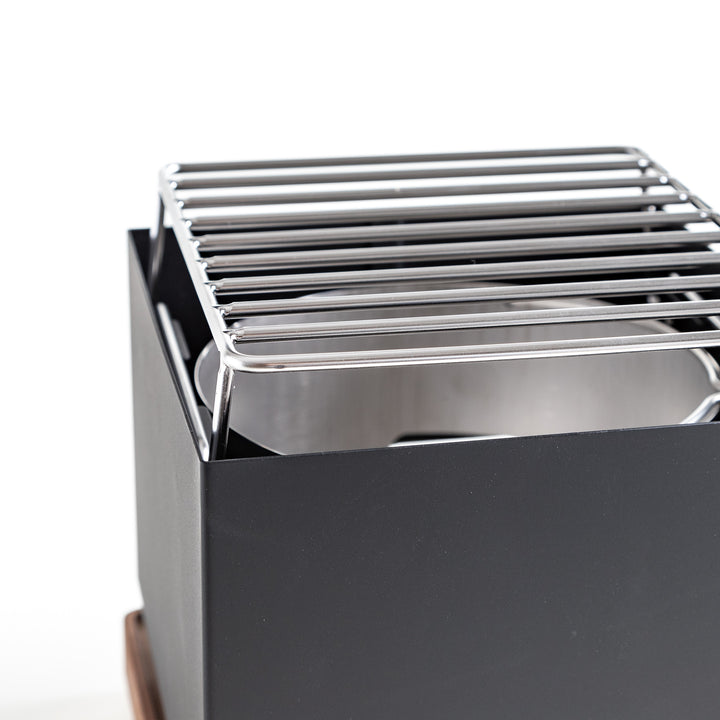 A black grill featuring a sturdy metal grate on top, ready for outdoor cooking and barbecues.