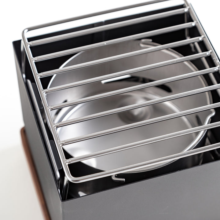 A close-up of a grill featuring a shiny metal grate, ready for cooking delicious meals outdoors.