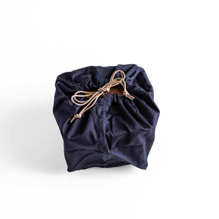 A compact drawstring bag, neatly tied, designed for holding items related to the Luxe Tabletop Grill.