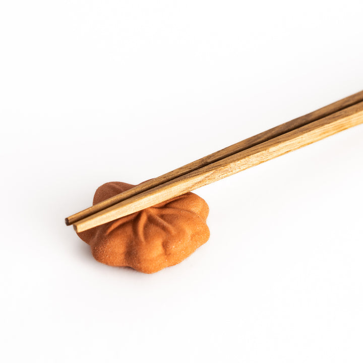 Close-up view of chopsticks placed on the maple leaf bun chopsticks rest, showcasing the delicate vein details and realistic bun texture.