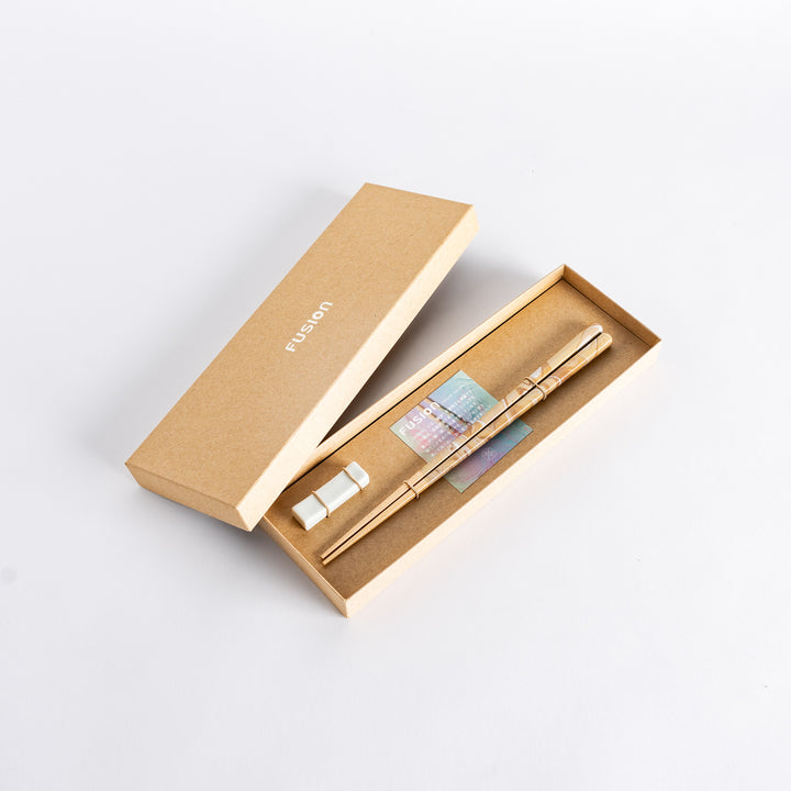 Elegant caramel-patterned chopsticks in a brown Fusion gift box with a porcelain chopstick holder.