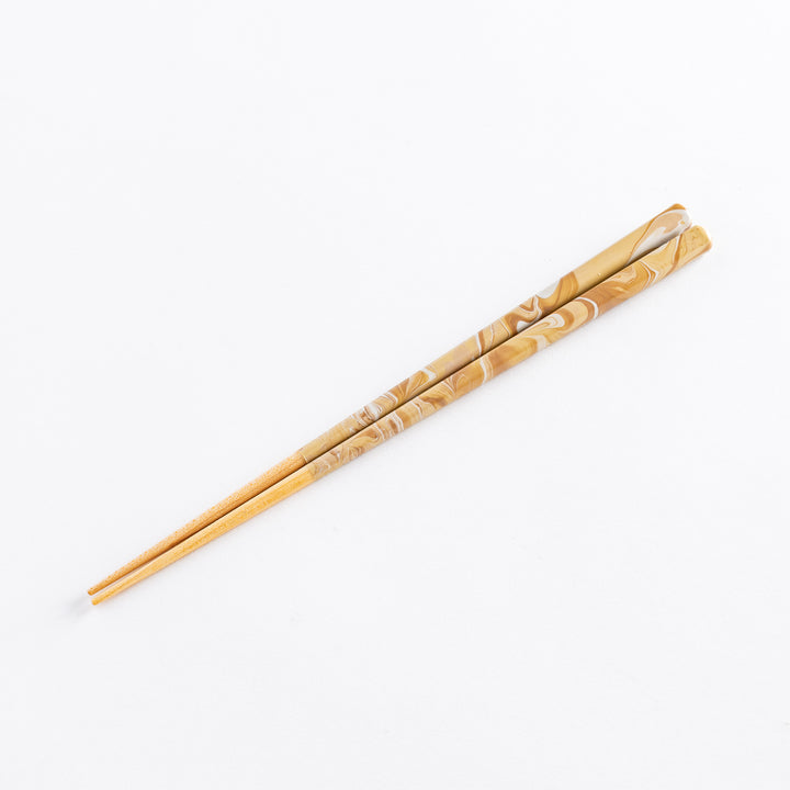 Detailed view of caramel-patterned chopstick handles, highlighting the swirling marbled design.