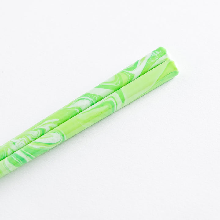 Close-up of mint green and white marble chopsticks, showing their smooth finish and stylish design