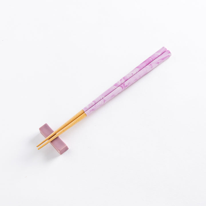 A hand holds the Lavender Breeze Fusion Chopsticks, showcasing the sleek purple design and natural wood.