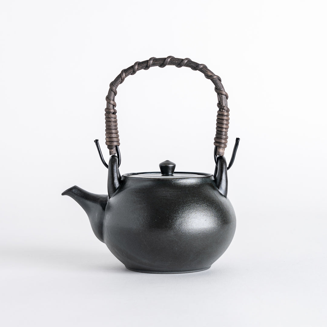 Slightly angled view of the matte black teapot, displaying its round shape and stylish braided handle for a contemporary look.