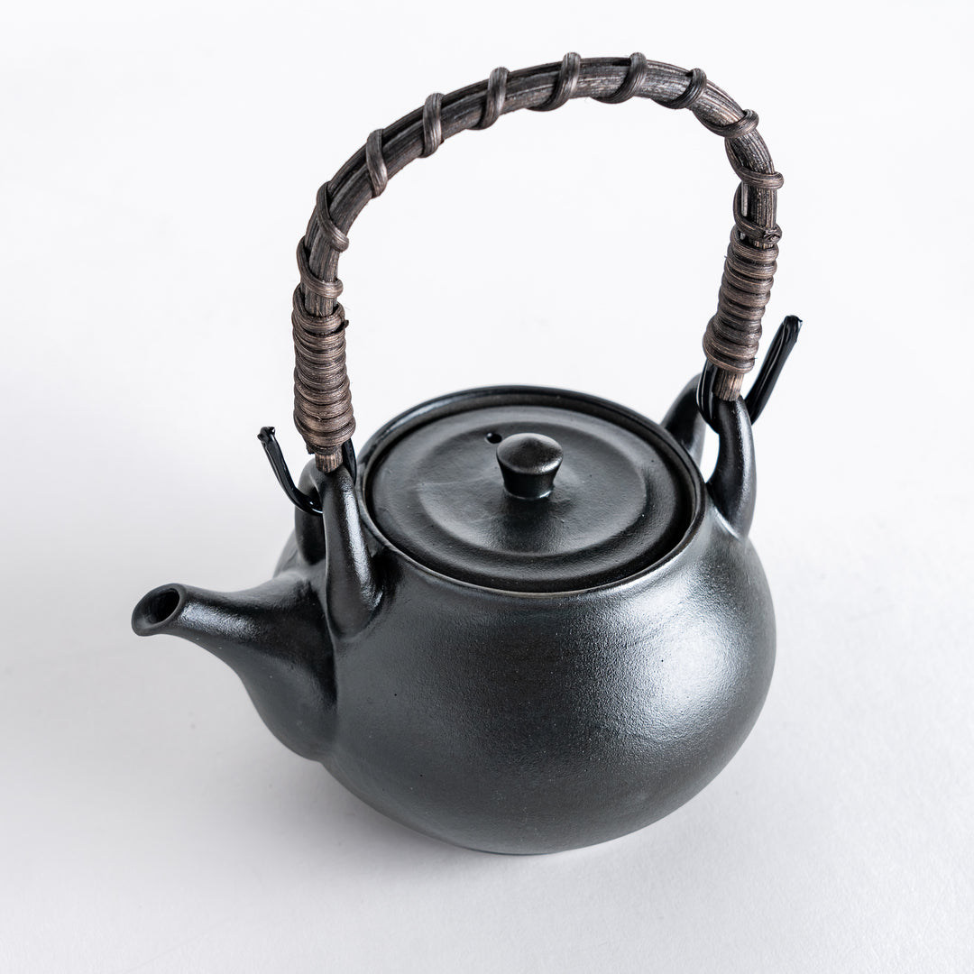 Matte black teapot with a round body and braided handle, showcasing a minimalist design for elegant tea service.