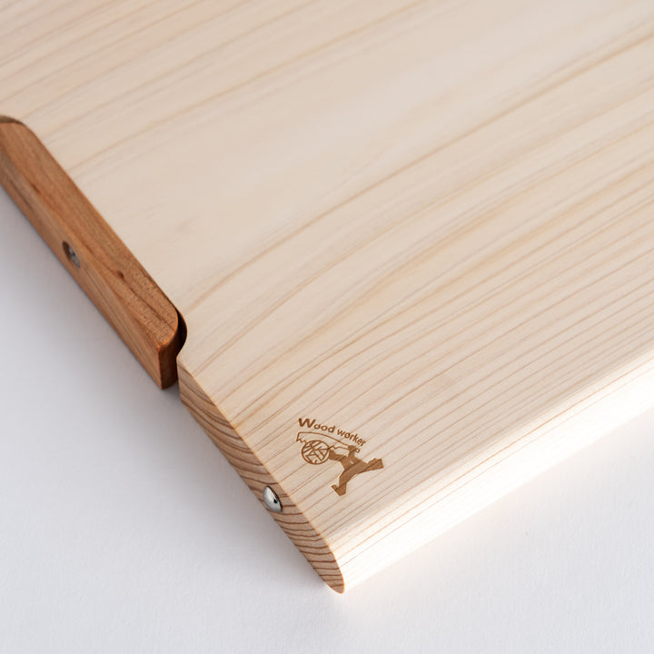 Close-up of the wooden handle and edge of the cutting board, highlighting the detailed craftsmanship and quality of the hinoki wood.