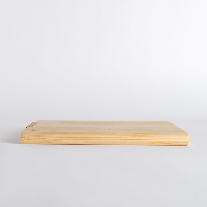 Top view of a rectangular cutting board with a smooth hinoki wood surface, showing natural wood grain and a polished finish.