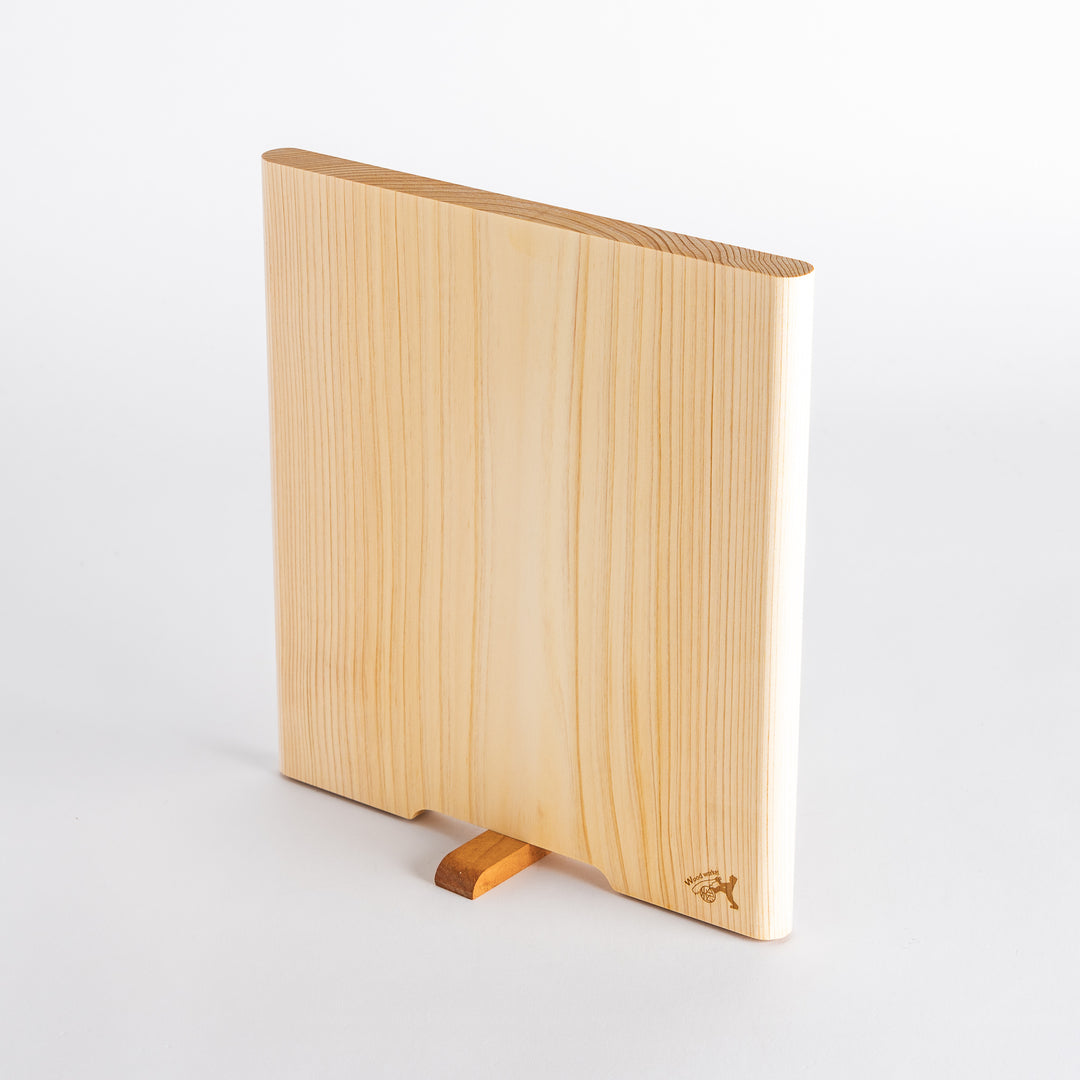 Side angle of a hinoki cutting board displaying the smooth edges and a contrasting wooden grip for enhanced usability.