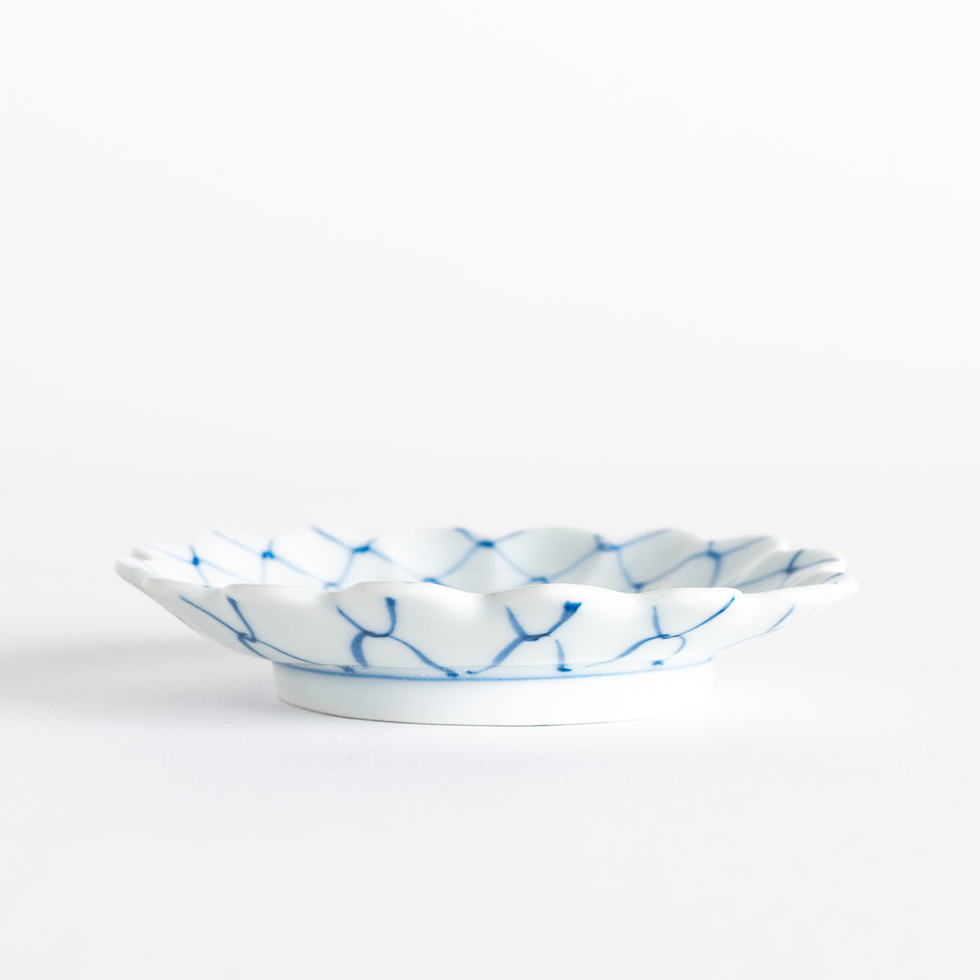 White sauce dish with a blue chrysanthemum mesh pattern and scalloped edges.