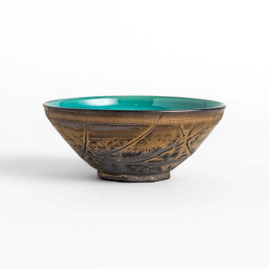 Textured brown Matcha bowl with a bright green interior, handcrafted ceramic for modern tea rituals.