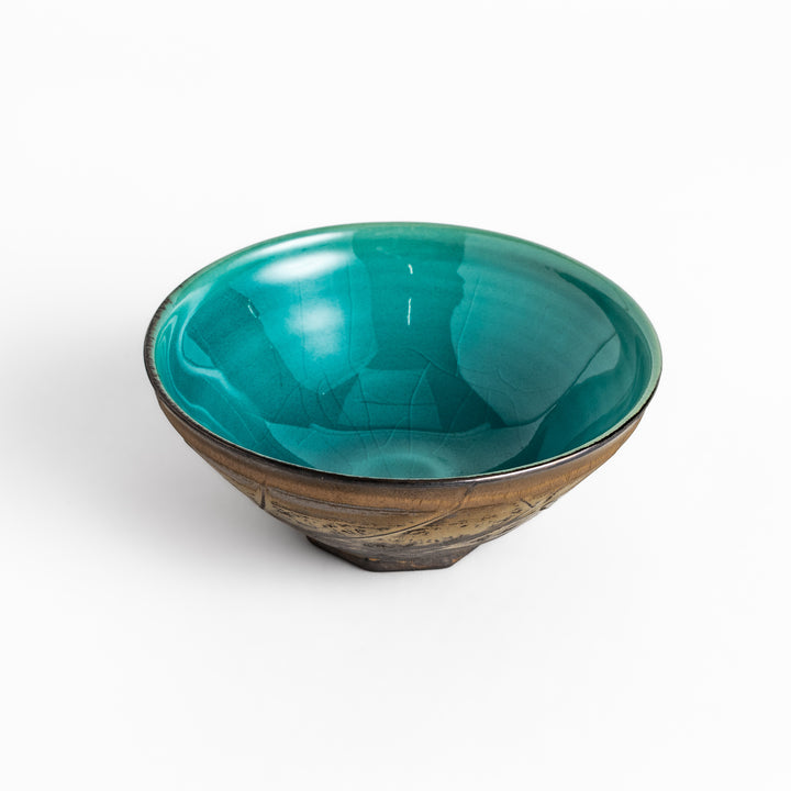 Textured brown Matcha bowl with a bright green interior, handcrafted ceramic for modern tea rituals.