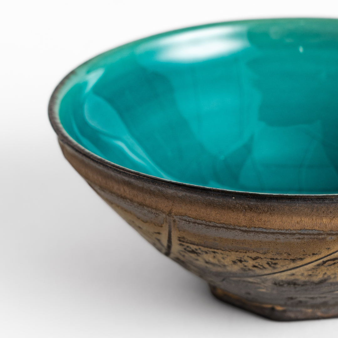 Textured brown Matcha bowl with a bright green interior, handcrafted ceramic for modern tea rituals.