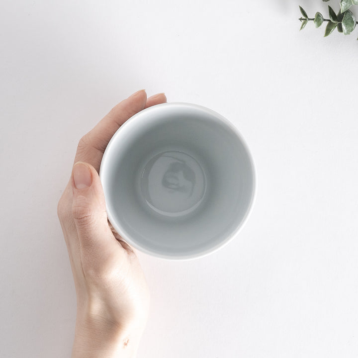 Top-down view of the Modern Indigo Circle Cup held in hand, showing the smooth white interior and circular rim.