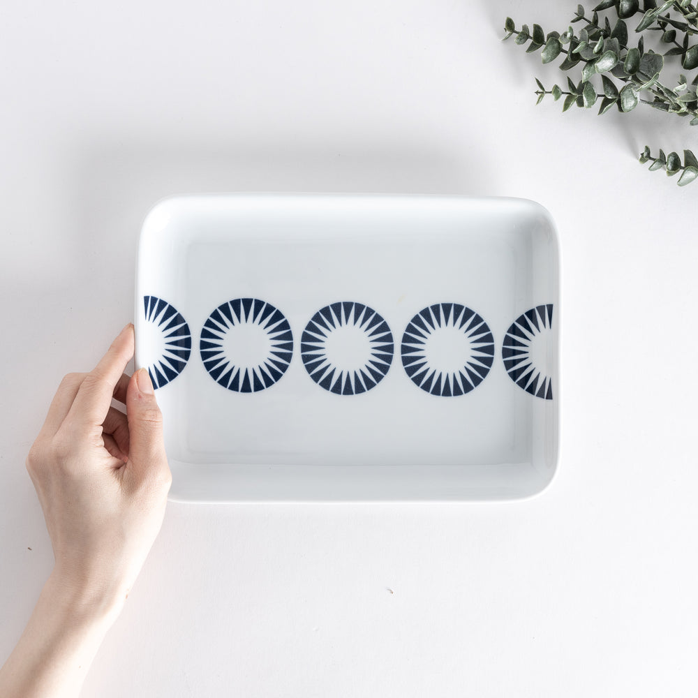 Handheld view of the Modern Indigo Circle Dinner Plate with five bold navy blue concentric circles aligned across the center.