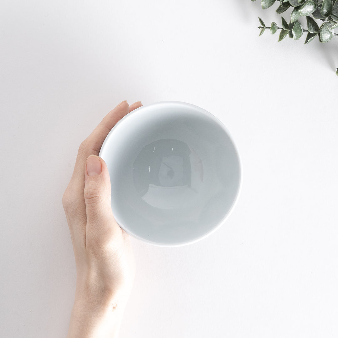 Handheld view of the Modern Indigo Circle Rice Bowl from above, showcasing the navy blue radiating circle pattern around the bowl.