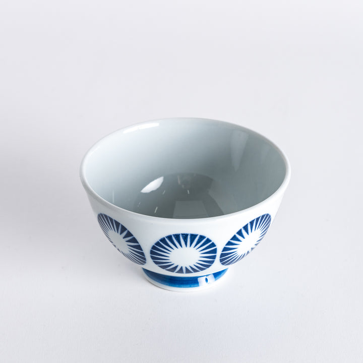 Slightly angled view of the Modern Indigo Circle Rice Bowl, highlighting the navy blue starburst circle design and blue base.