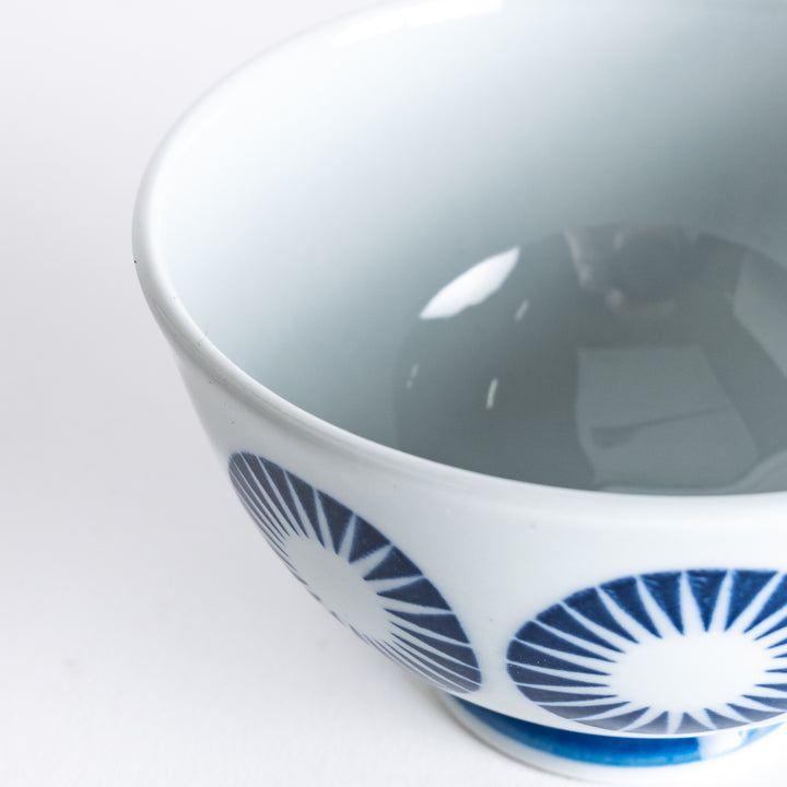 Slightly angled close-up of the Modern Indigo Circle Rice Bowl, focusing on the intricate blue circle pattern and the smooth white surface.