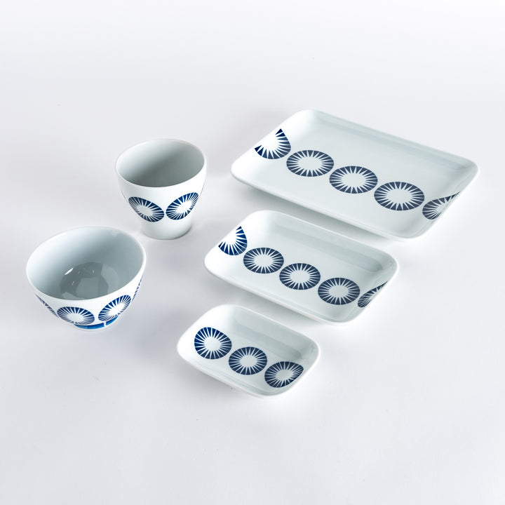 Five pieces featuring the Modern Indigo Circle design, including two cups, two rectangular plates, and a small dish, all adorned with navy blue radiating circle patterns.