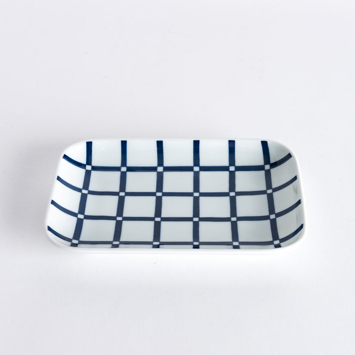 A dessert plate with a modern indigo lattice pattern, captured at a slight angle to show the grid design and depth.