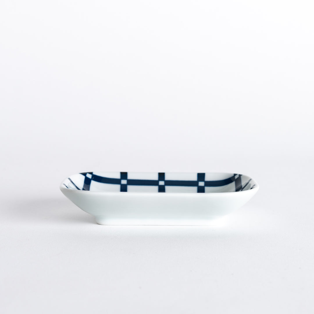 Sauce dish shown at a slight angle, highlighting the navy blue lattice design and clean, smooth edges.