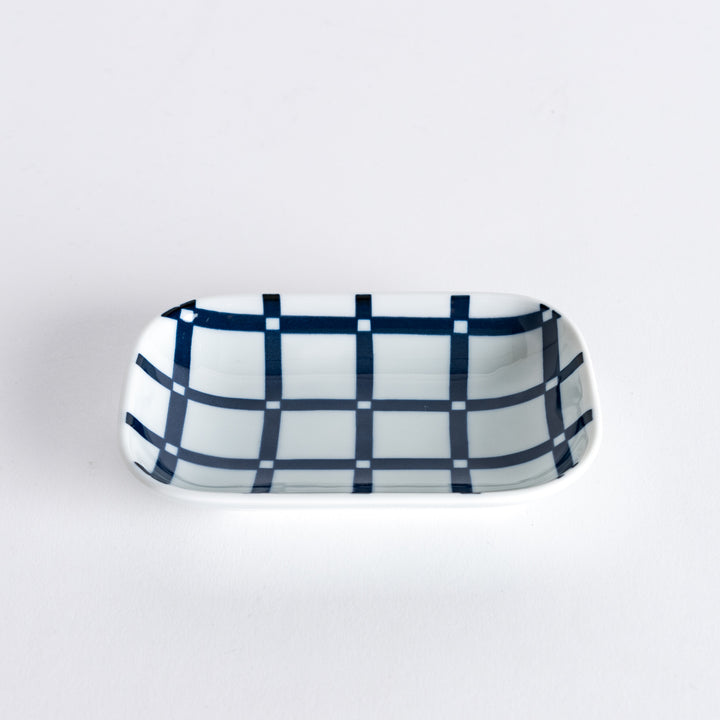 Side view of the sauce dish, showcasing the depth and the uniform navy blue lattice pattern across the surface.