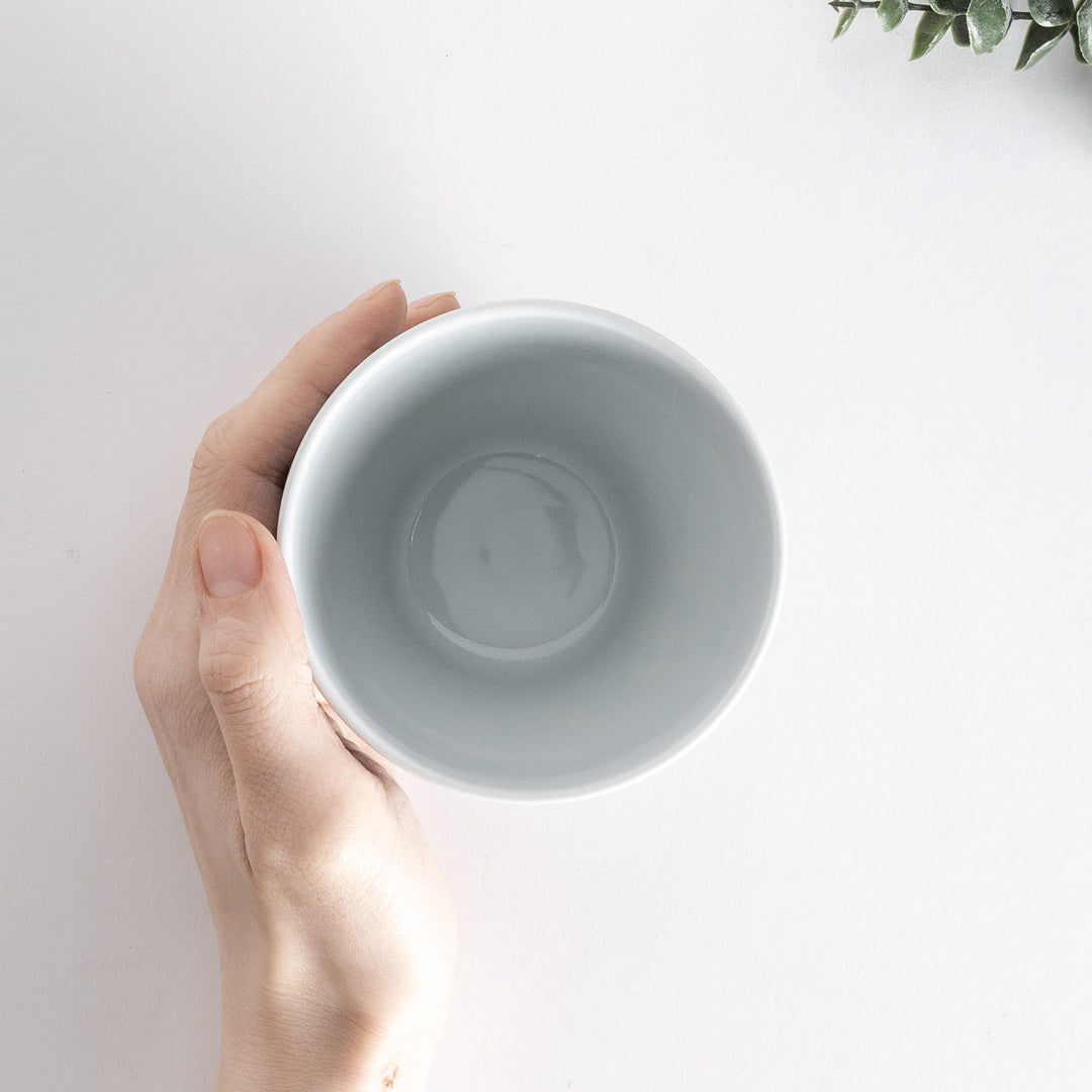 Top view of the Modern Indigo Pine Cup held in hand, showing the wide opening and glossy white interior.