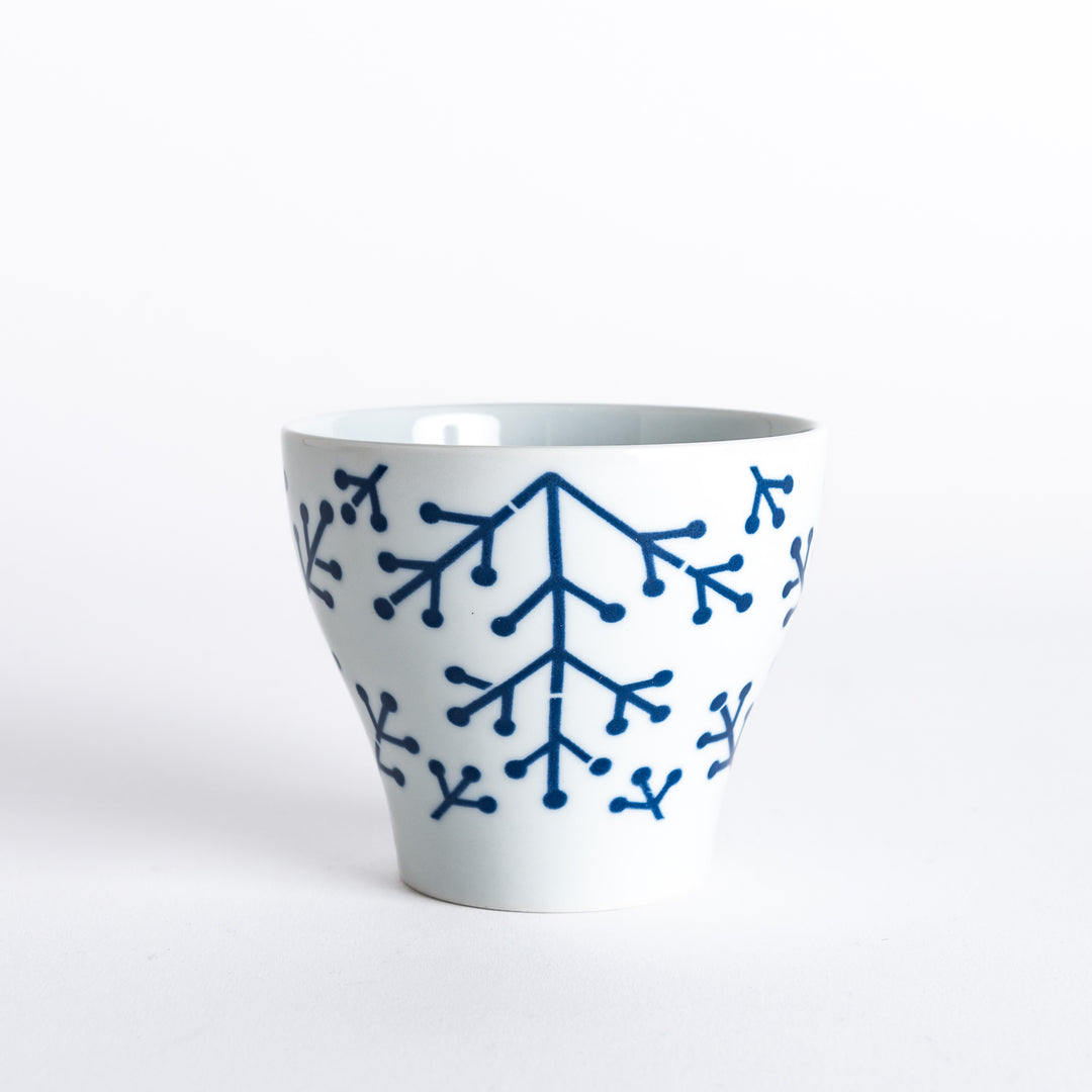 Side view of the Modern Indigo Pine Cup, displaying the elegant navy blue pine branch pattern and the footed base.