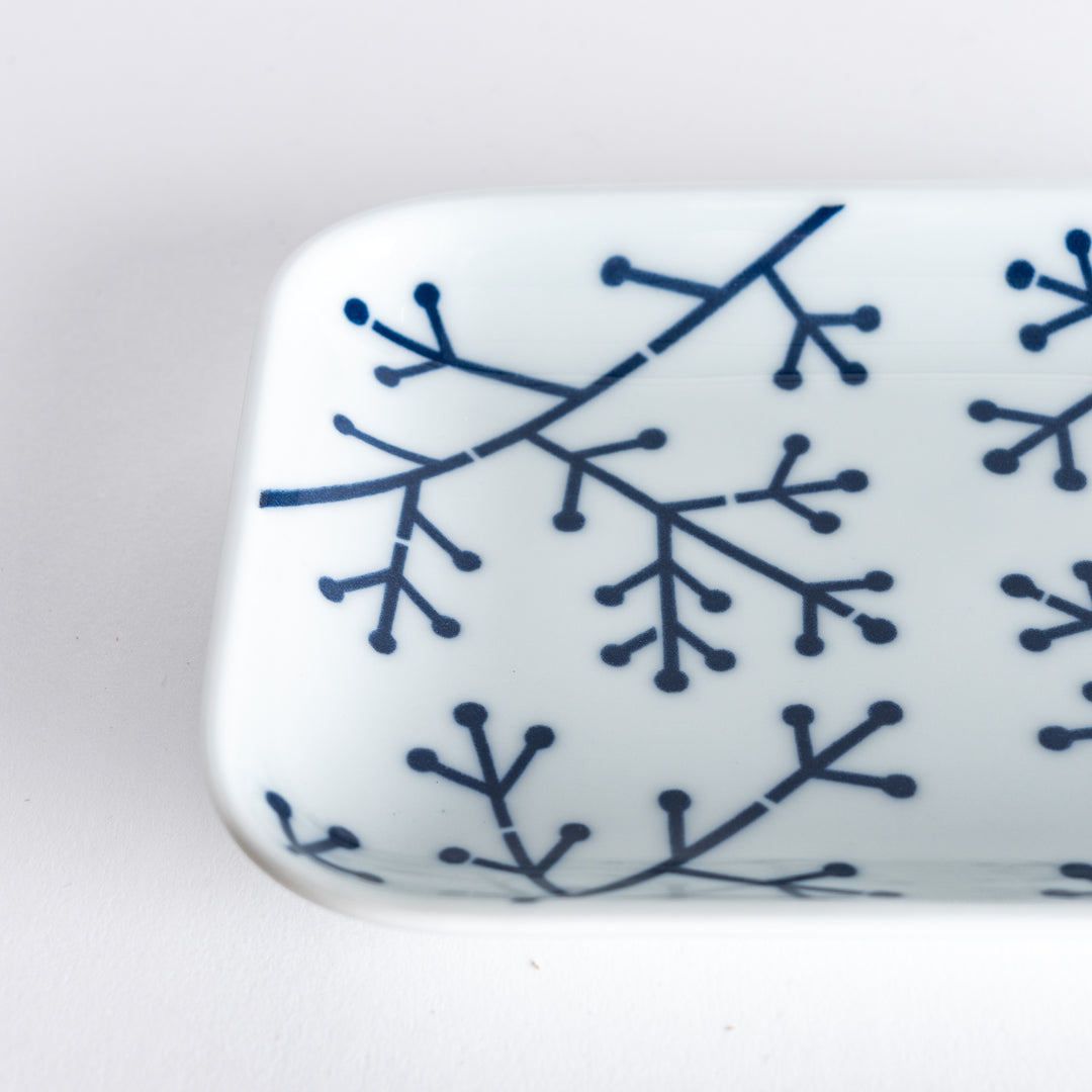 Close-up of the dessert plate’s indigo pine branch pattern, focusing on the intricate geometric lines and dots.