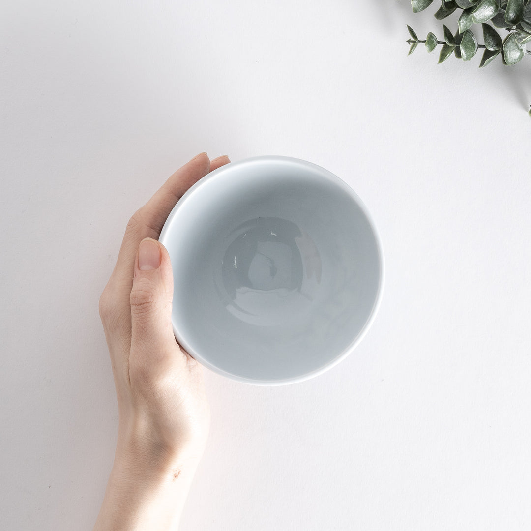 Handheld view of the Modern Indigo Pine Rice Bowl from above, showcasing the navy blue pine branch design on a white background.