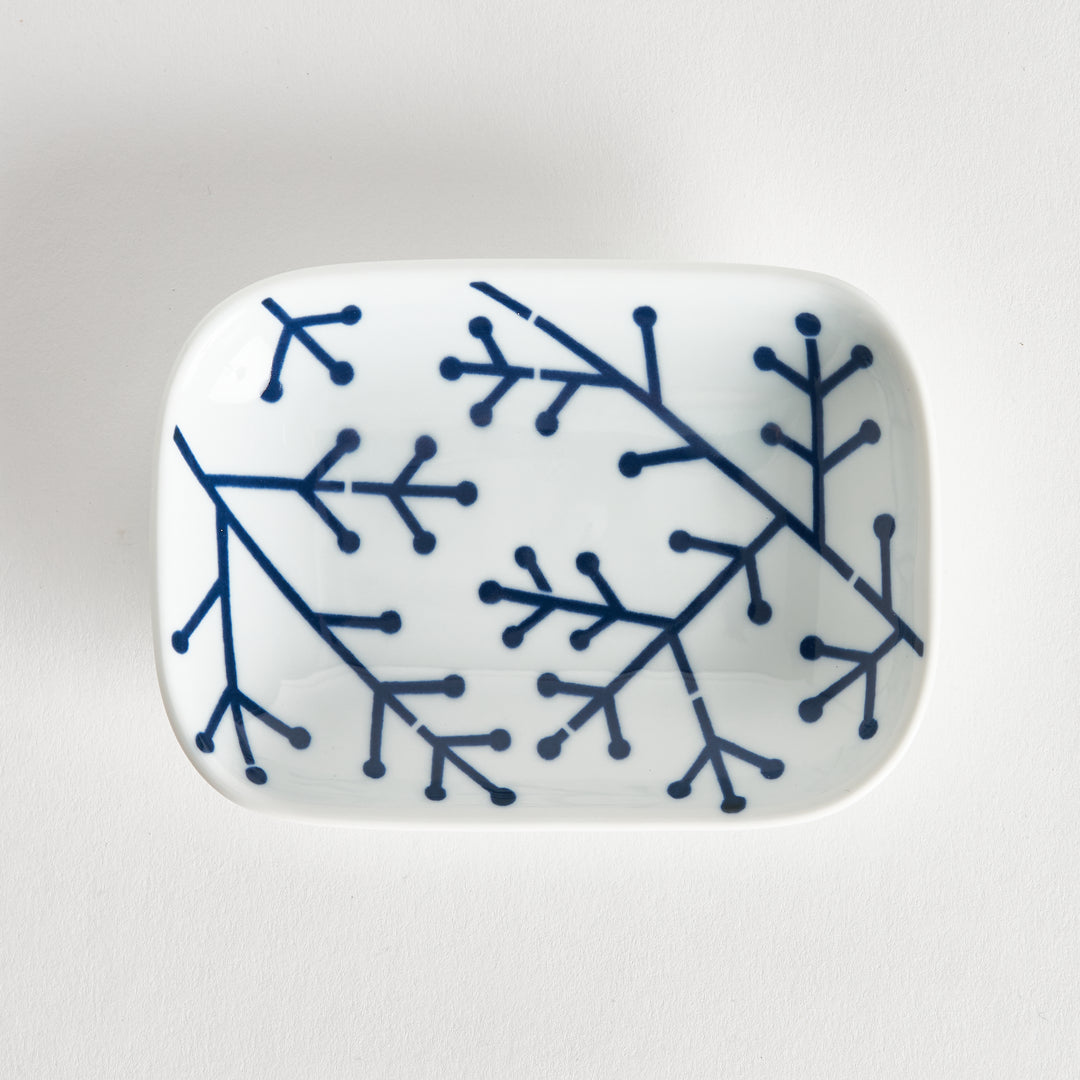 Rectangular white porcelain sauce dish featuring a bold indigo pine branch design. The clean lines highlight its modern style.