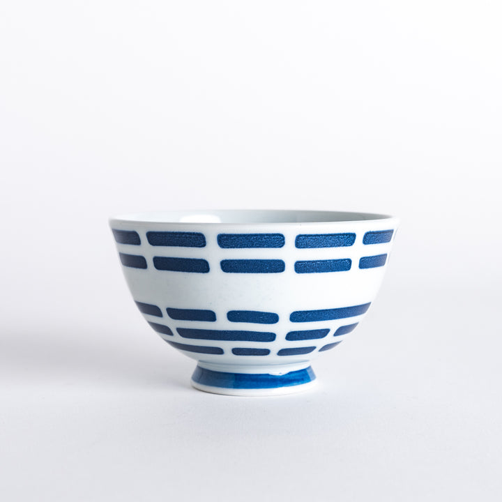 Navy blue rice bowl featuring horizontal line pattern on the outside, with a matching blue base. Simple, modern design."